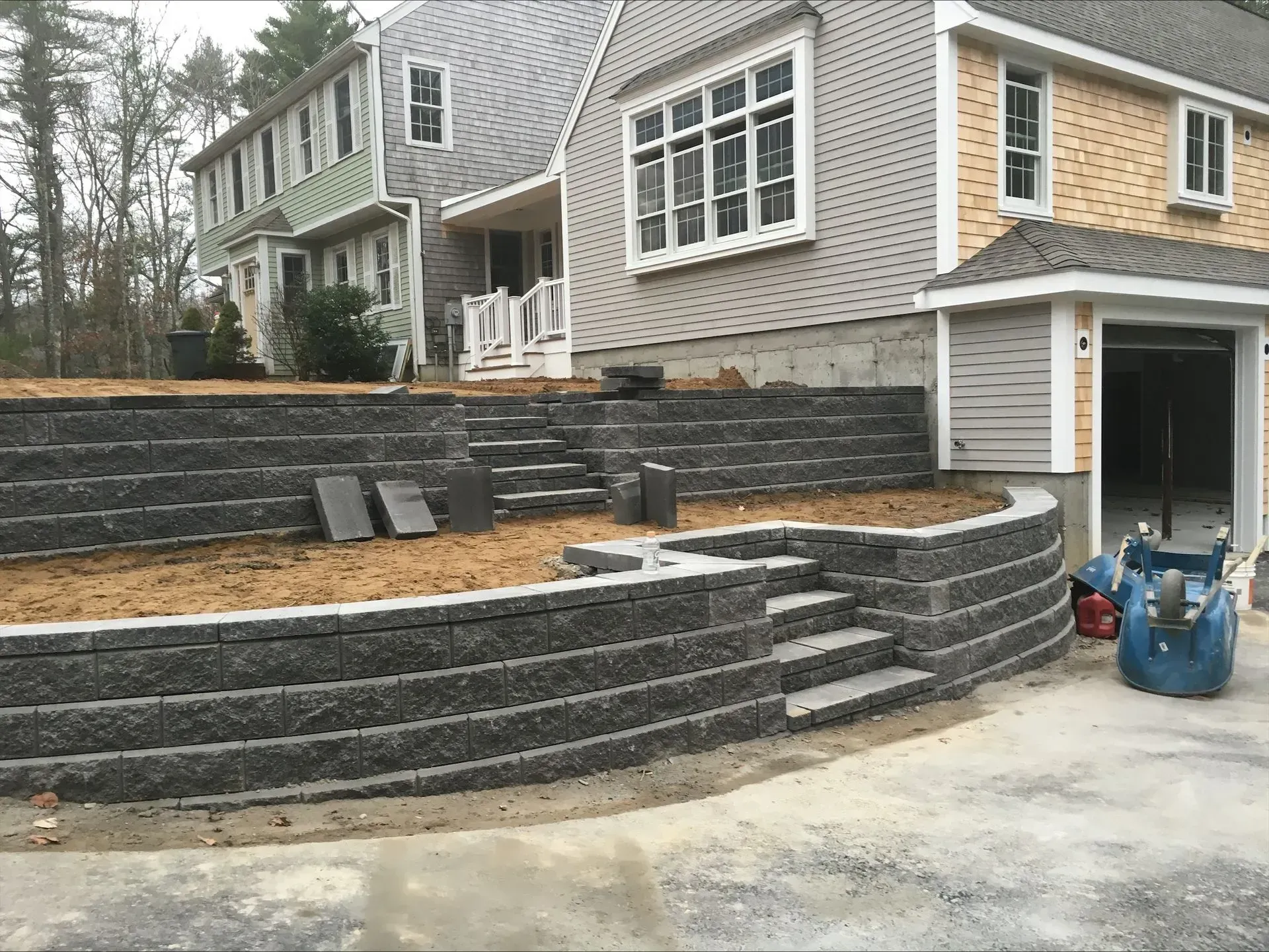 A large house with a retaining wall in front of it.