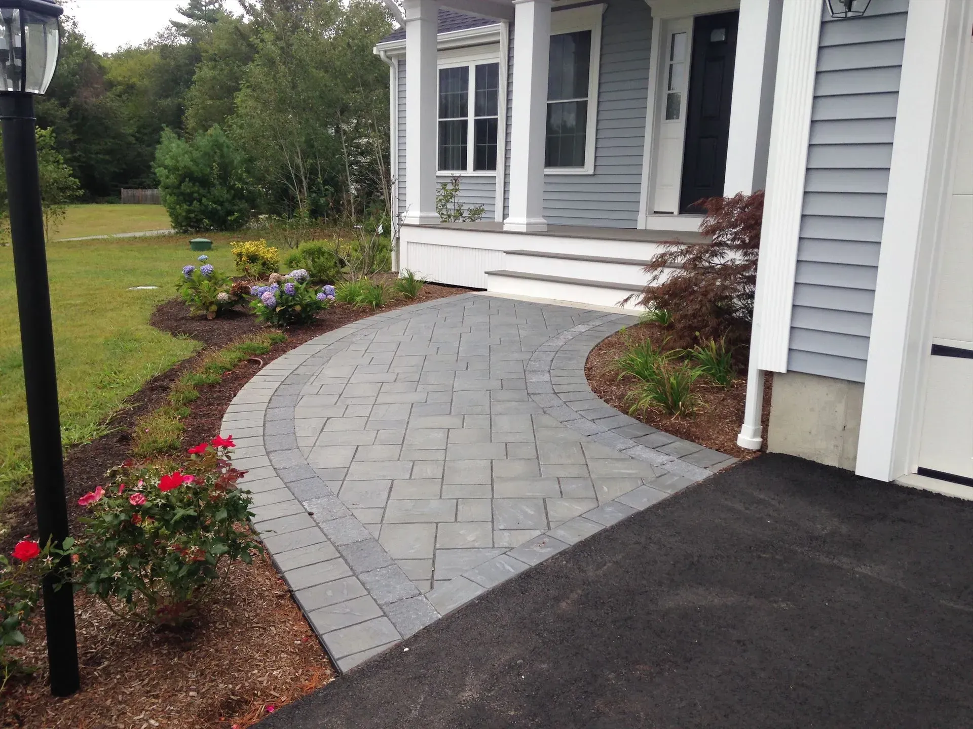 A brick walkway leading to the front of a house