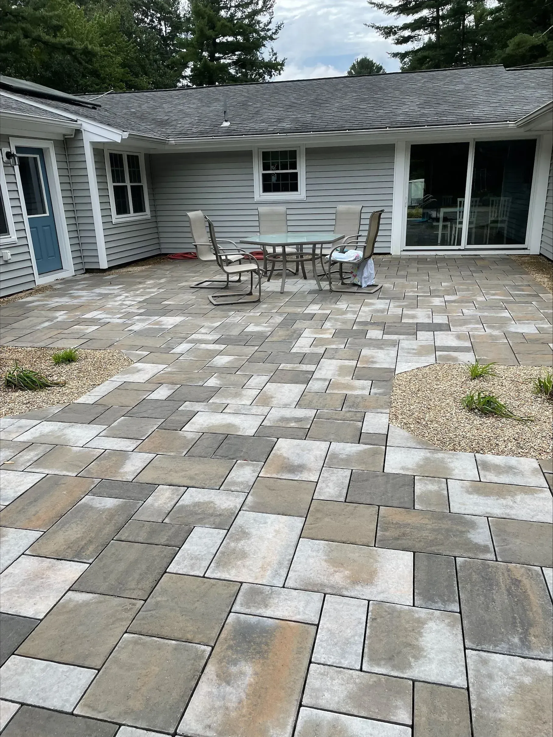 A patio with a table and chairs in front of a house.
