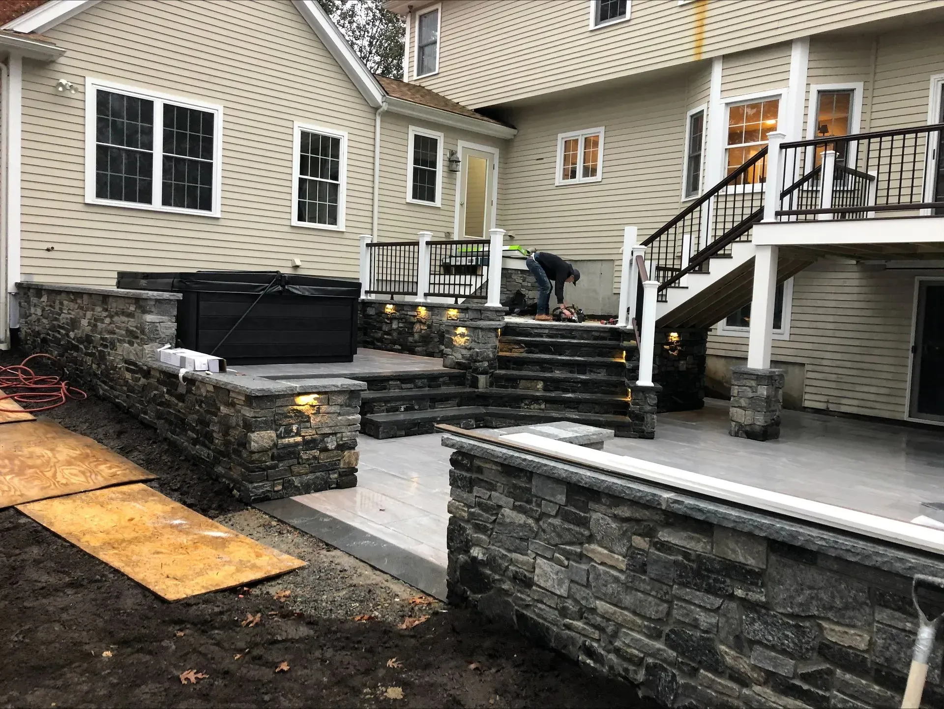 A large house with a patio and stairs in front of it.