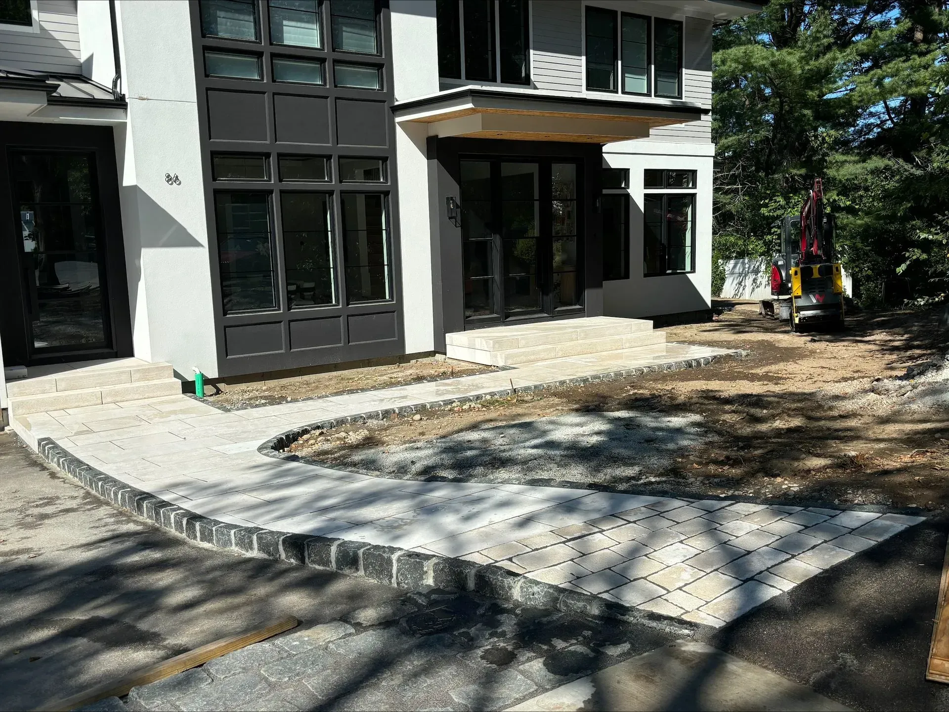 A large white house with a walkway in front of it.