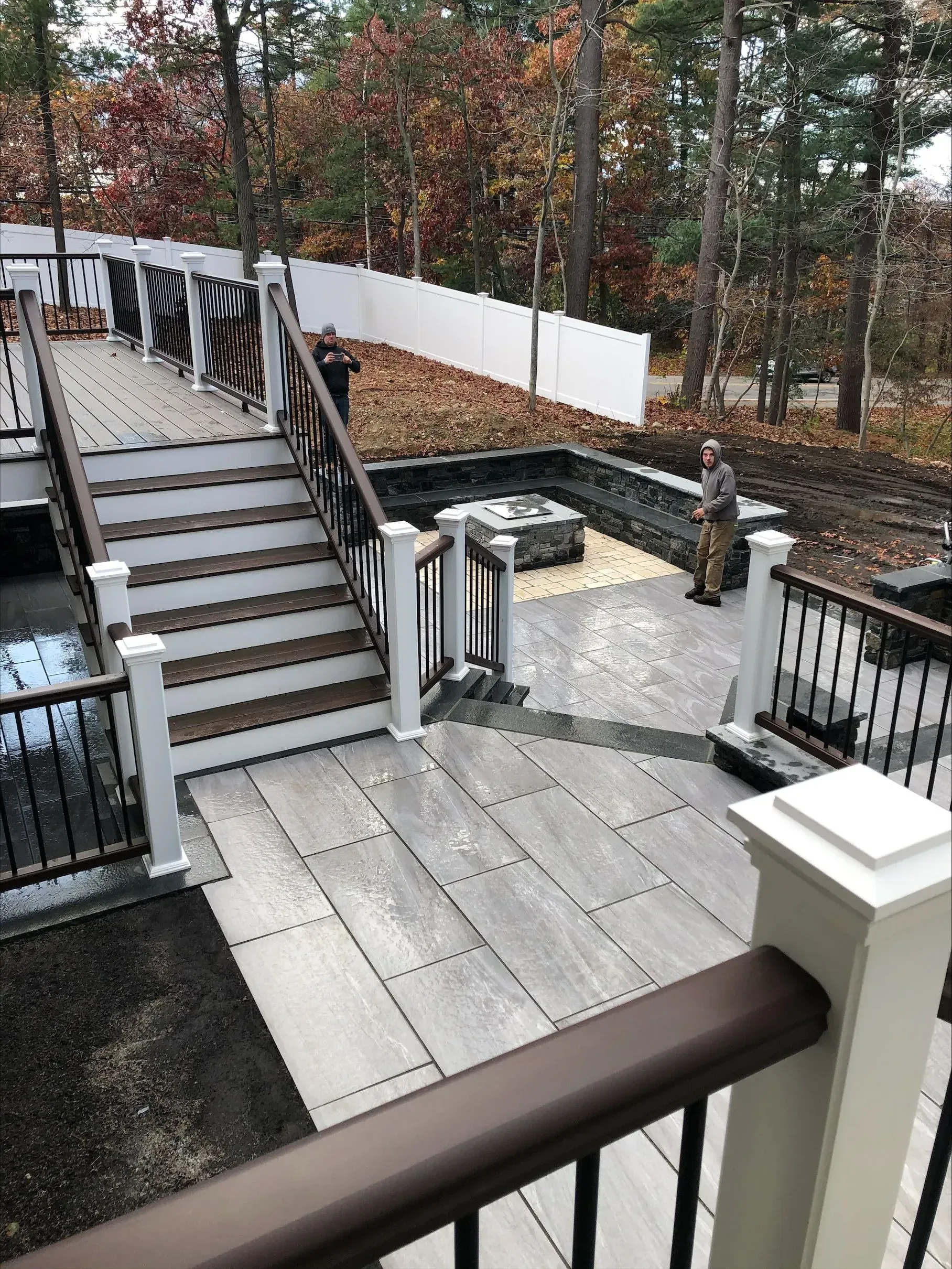 A man is standing on a deck with stairs leading up to it.