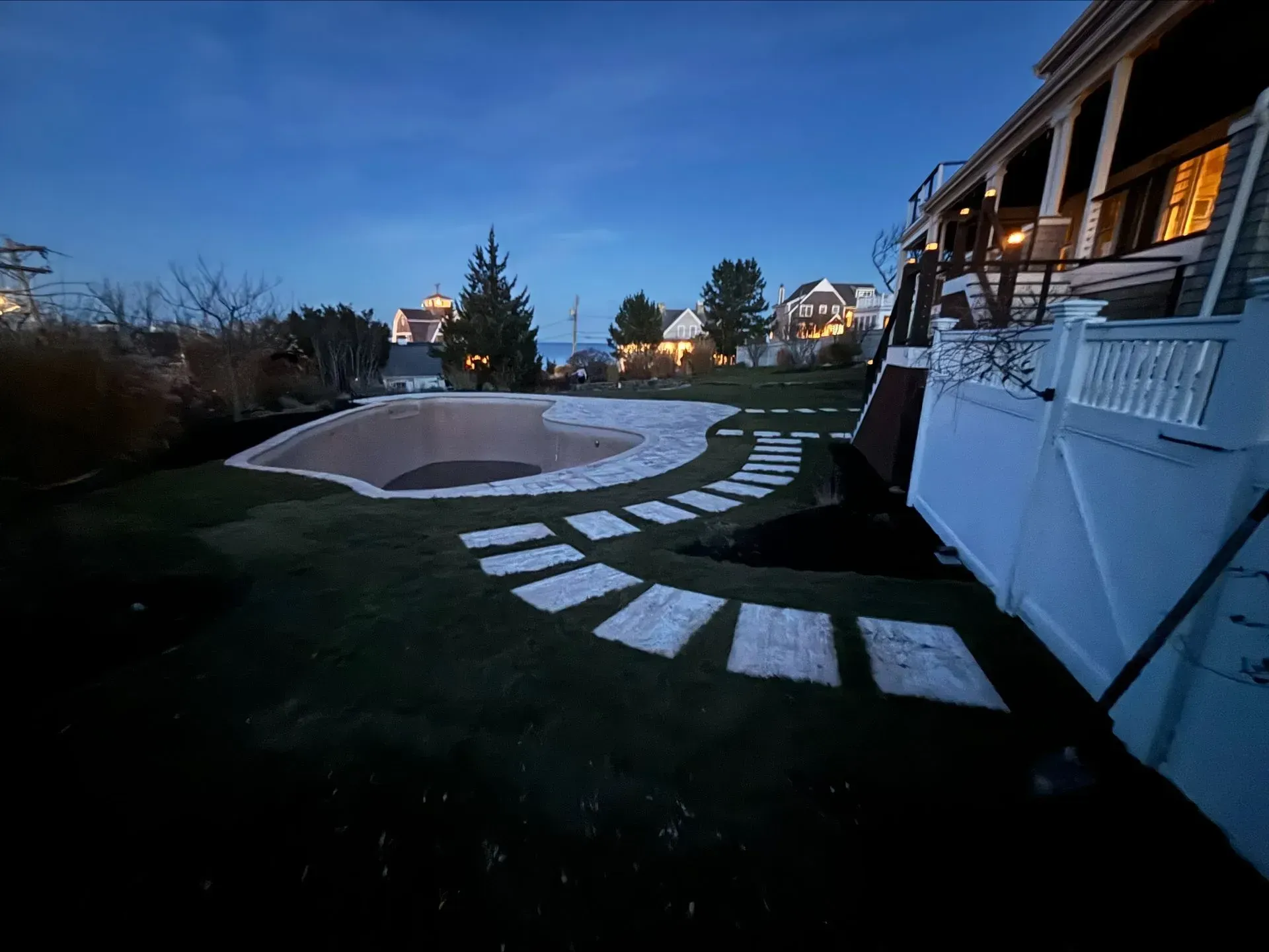 A house with a swimming pool in the backyard at night