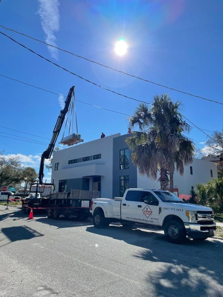 A white truck is parked in front of a building under construction.