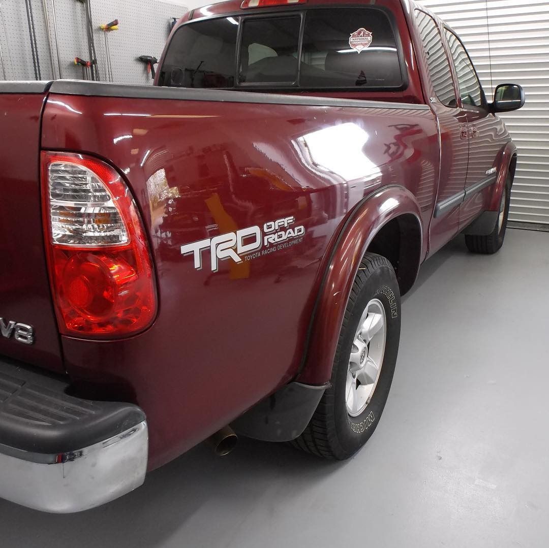 Burgundy Toyota Tundra truck with TRD Off-Road sticker, parked inside a garage.