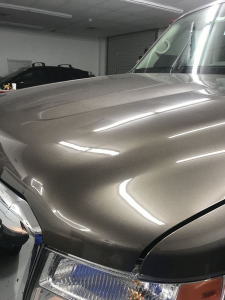 Brown car hood with bright reflections.