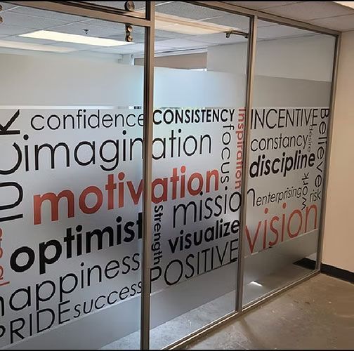 Office glass wall with motivational words like confidence, imagination, motivation, and vision