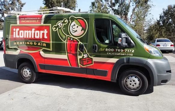 The iComfort heating & air service van parked outdoors, red and green with logo and phone number