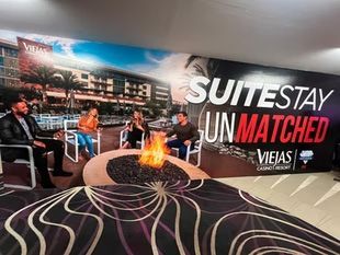 Suitestay lounge ad with a fire pit, modern seating, and a bold “UNMATCHED” banner by Viejas.