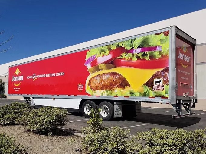 Red A&W fast-food delivery truck parked outdoors with large burger and sandwich graphics on the side
