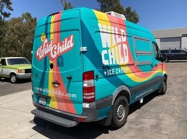 Turquoise ice cream truck with colorful “Just Chill” branding parked in a lot.