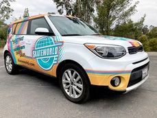 Colorful compact SUV with “Skateworld” branding parked outdoors on a road