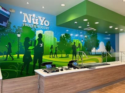 NuYo Frozen Yogurt shop with green mural, counter, and self-serve yogurt machines
