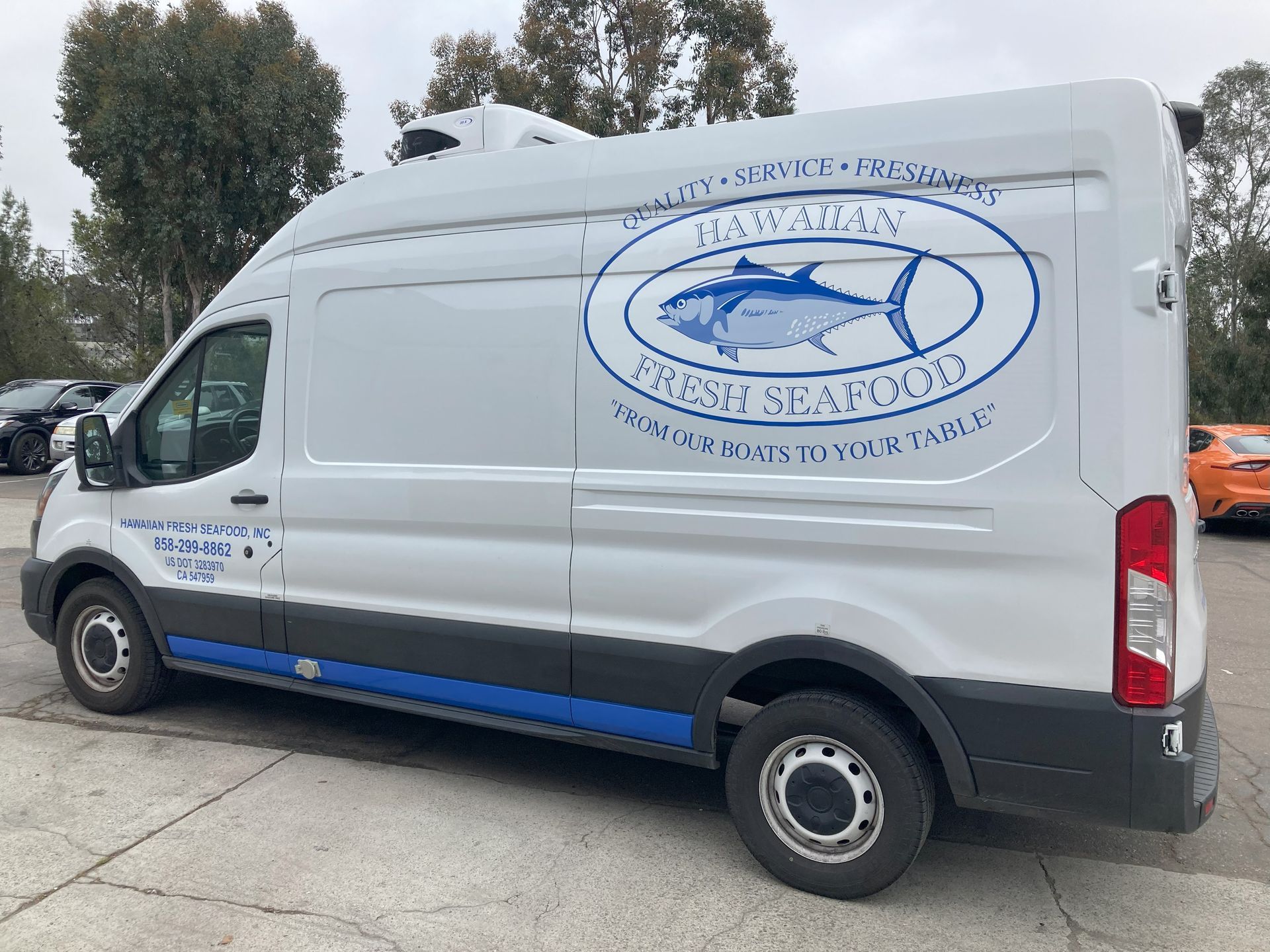 White seafood delivery van with blue logo parked outdoors on a street