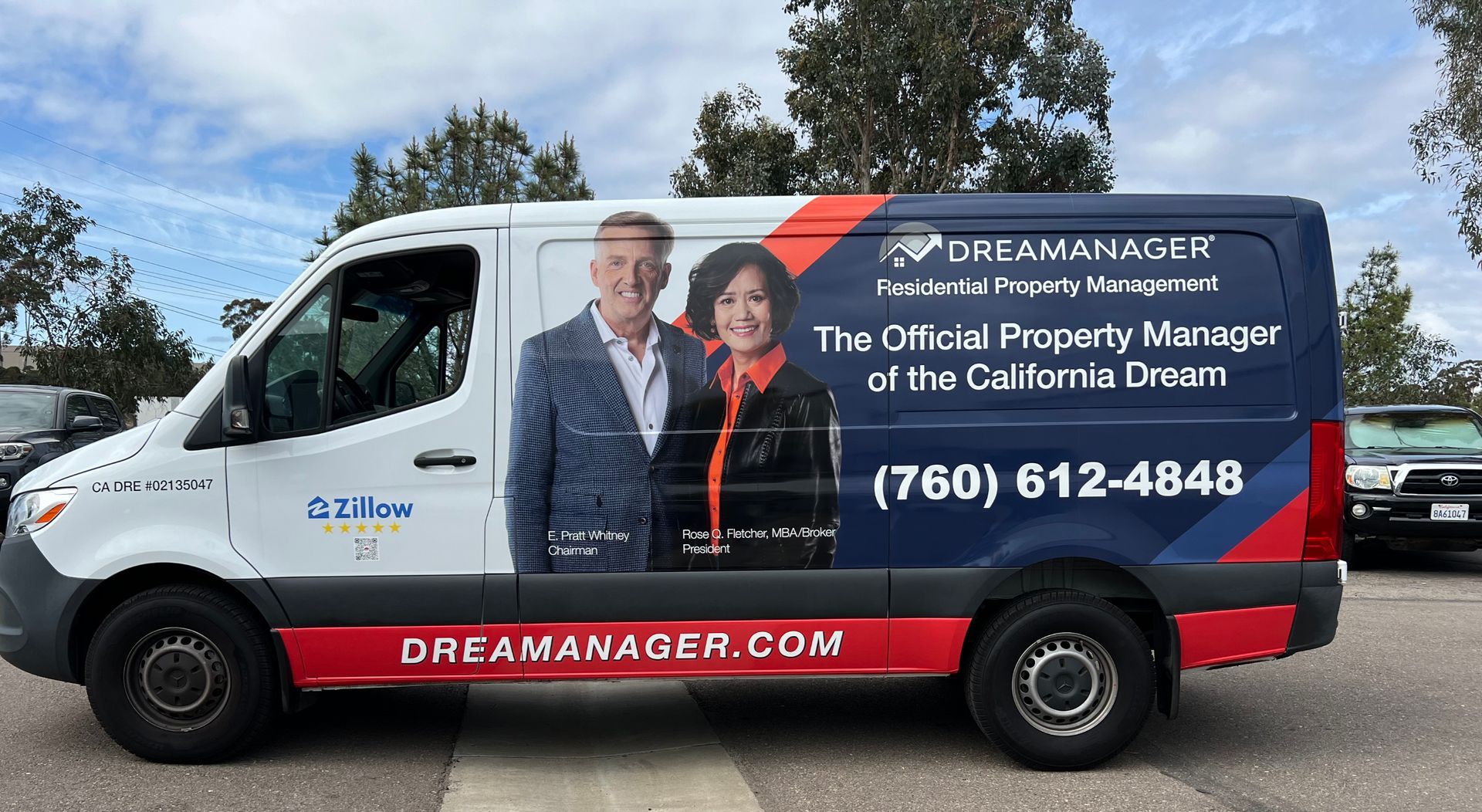 DreamMakers van wrapped with business ad, black and red design, parked outdoors under a blue sky