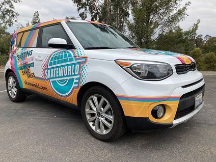 Colorful SANITWORLD-branded SUV parked outdoors with bright decals and orange accents