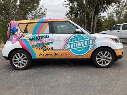 Skateworld-branded white SUV with colorful skate-themed graphics parked outdoors