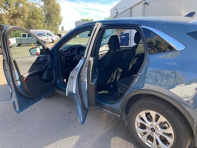 Blue SUV with both front doors open in a parking lot, showing the interior and driver’s seat