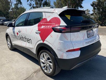 White and gray service SUV with branding and a red heart graphic parked outdoors