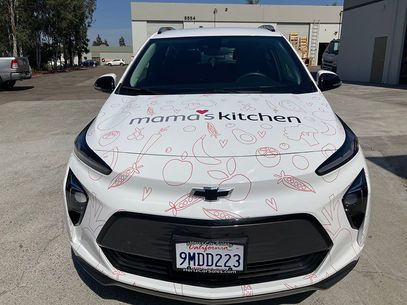 White-branded car parked outdoors with Mama's Kitchen on the hood and front license plate visible