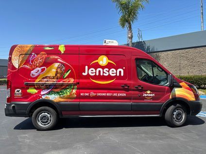 Red Jensen delivery van with colorful fruit graphics parked on a street