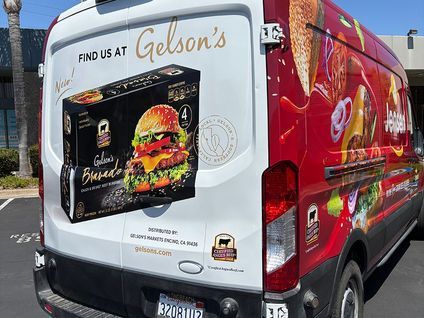 Branded delivery van wrapped in red and white advertising Glen’s cheeseburgers.