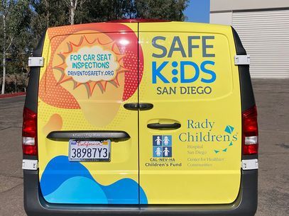 Yellow van with Safe Kids San Diego and Rady Children’s Hospital car seat inspection logos on the side