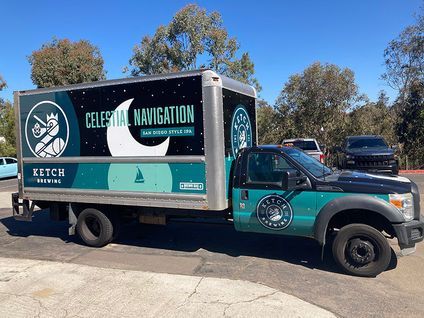 Turquoise and black delivery truck with Celestial Navigation branding parked outdoors under a blue sky