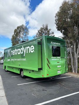Green Retradyne truck parked in a lot under cloudy skies