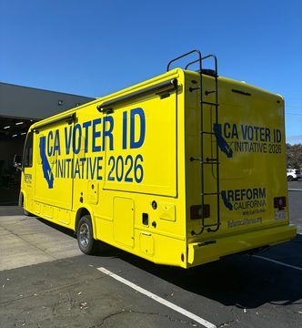 Bright yellow campaign truck with CA Voter ID Initiative 2026 parked outdoors in sunlight