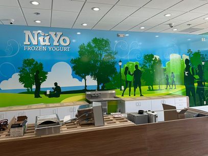 Nuyo Frozen Yogurt shop interior with colorful mural and self-serve yogurt counter