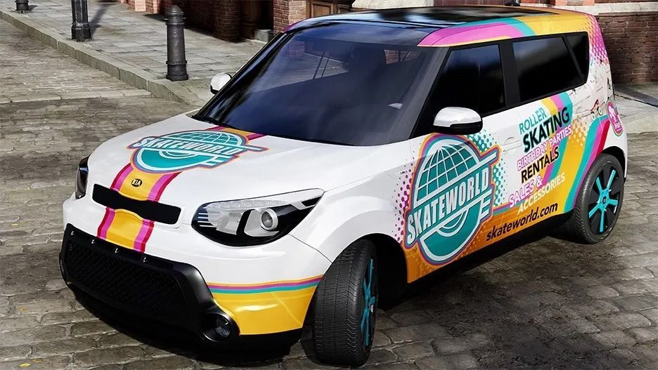 A colorful, wrapped white compact car is parked on a cobblestone street, featuring teal, pink, and yellow graphics.