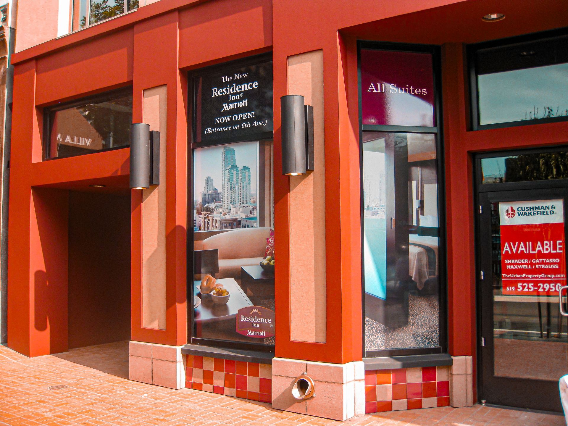 Red storefront with large windows and a red AVAILABLE sign on the door.