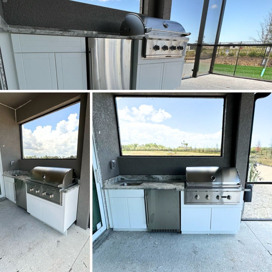 Outdoor kitchen with white cabinets, stainless steel grill, and a view of the landscape.