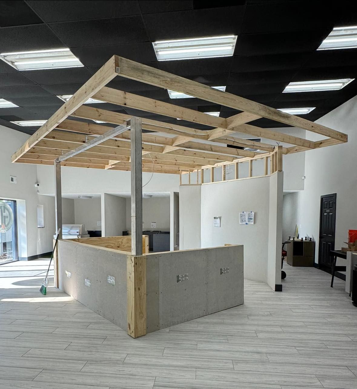 Construction of a counter with a wooden frame and metal supports, in a brightly lit room.