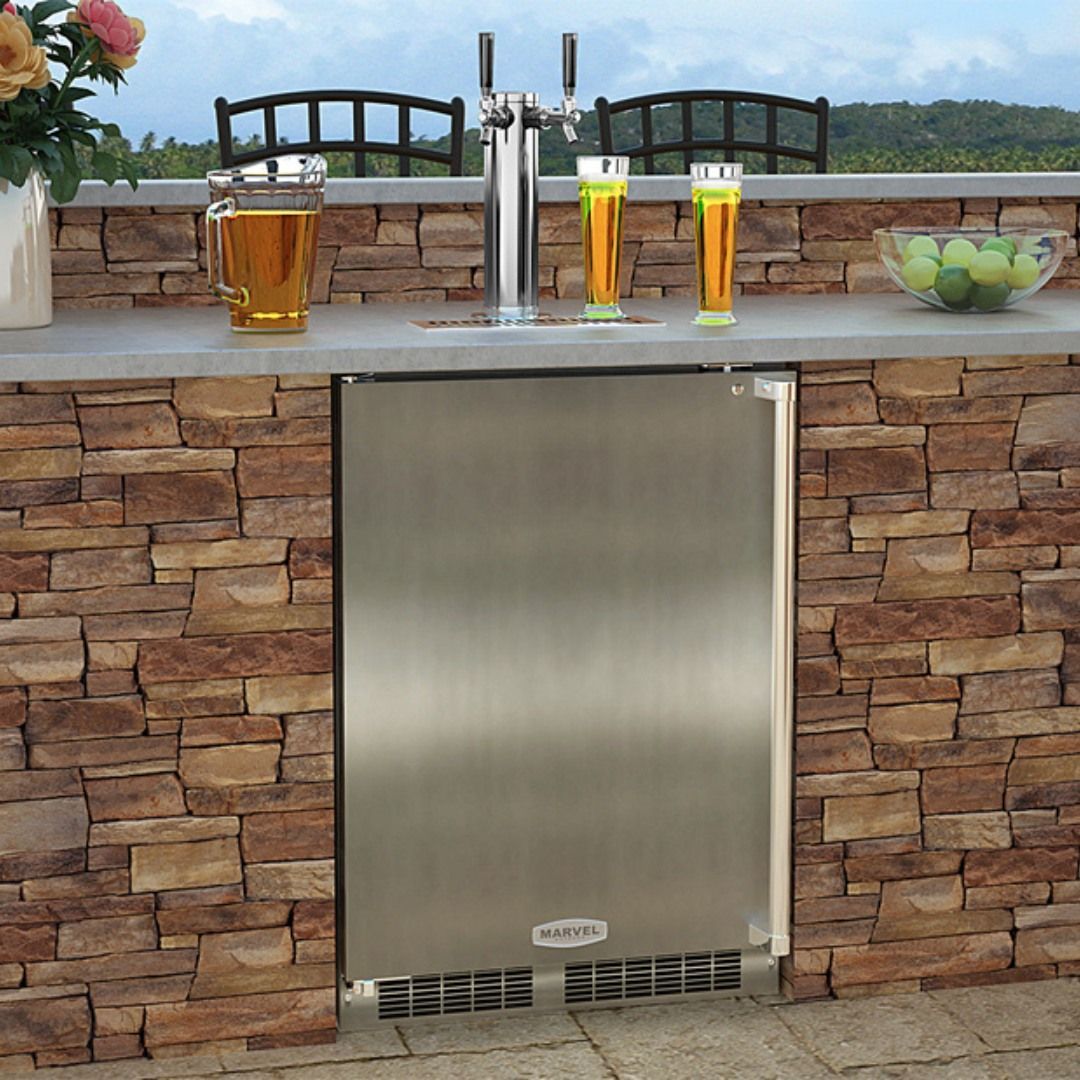 Stainless steel outdoor beer dispenser built into a stone bar, with tap, glasses of beer.