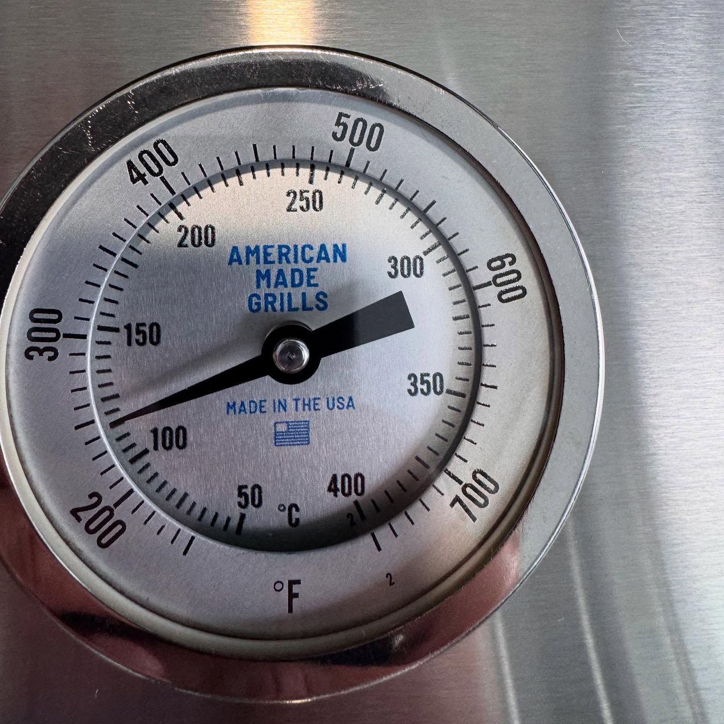 Grill thermometer dial reading approximately 300°F with text 