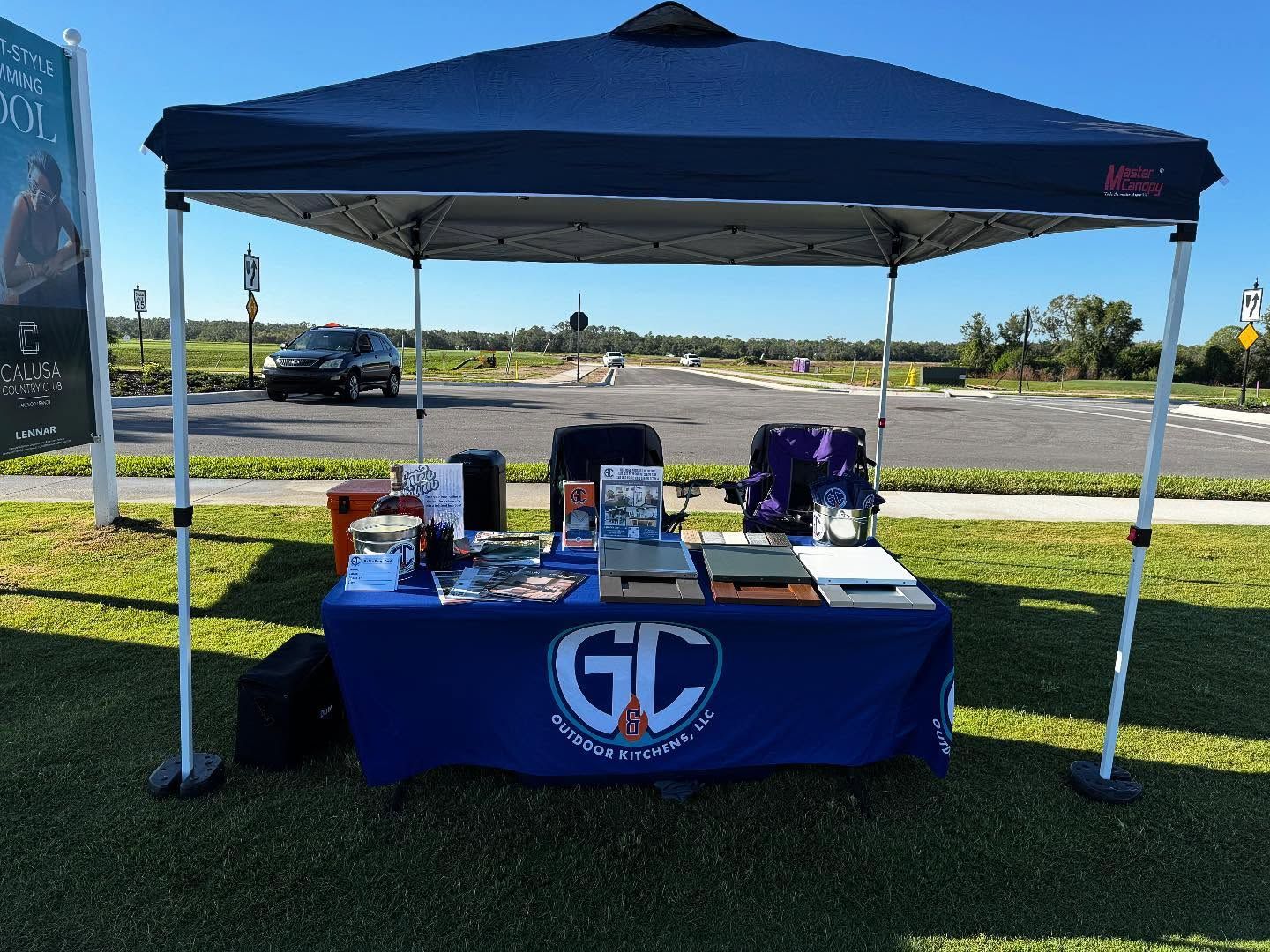 Blue tent with table displays marketing materials for 