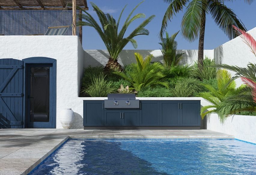 Outdoor kitchen with pool, palm trees, blue cabinets, and white stucco walls.