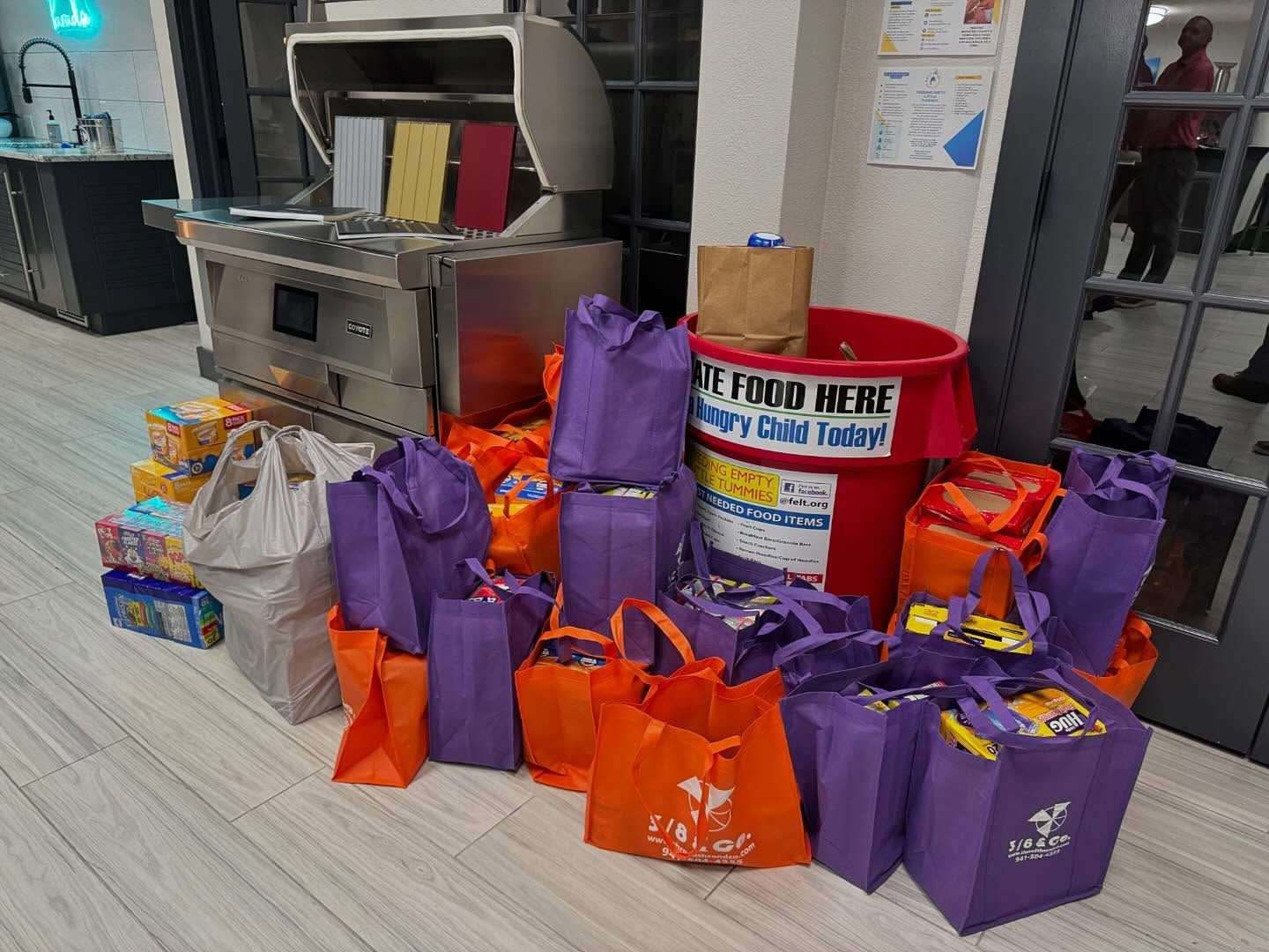 Food donations in purple and orange bags and a red donation bin.