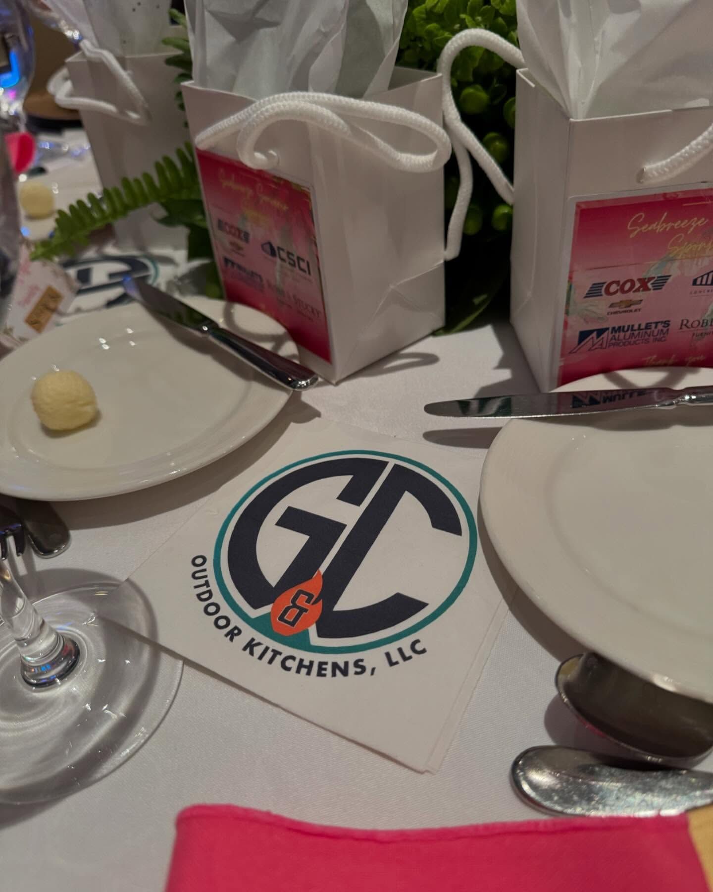 Table setting with plates, silverware, and gift bags, featuring 