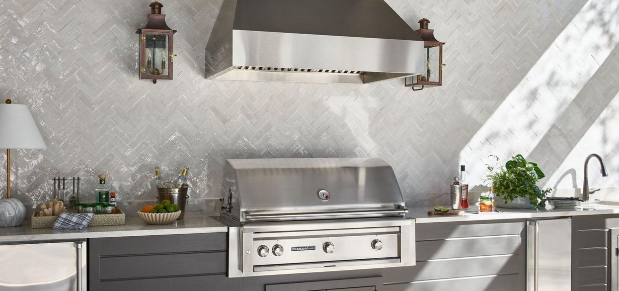 Gray roof with multiple gables, small windows, and wooden trim on a white building.