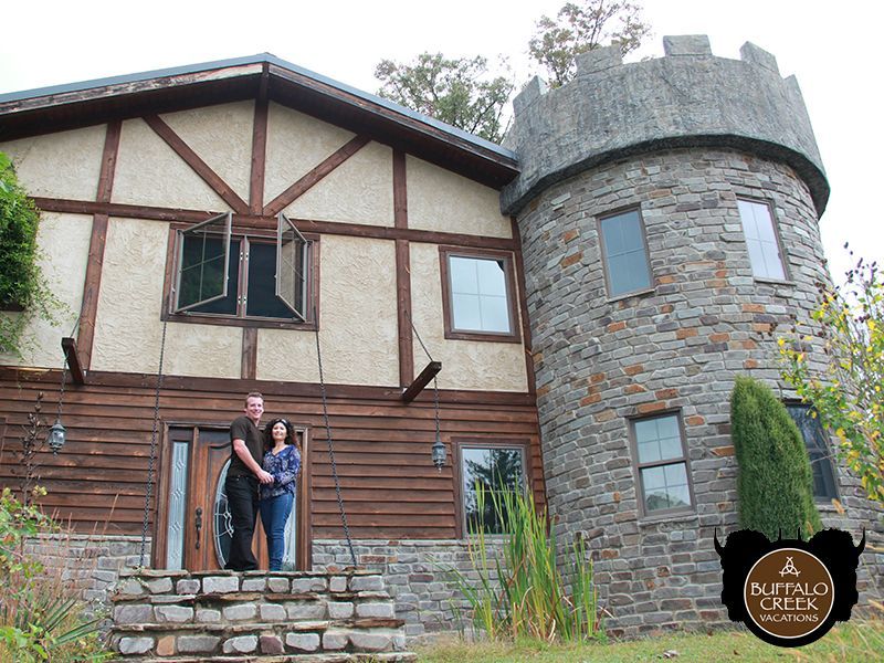 A couple standing in front of a castle shaped house