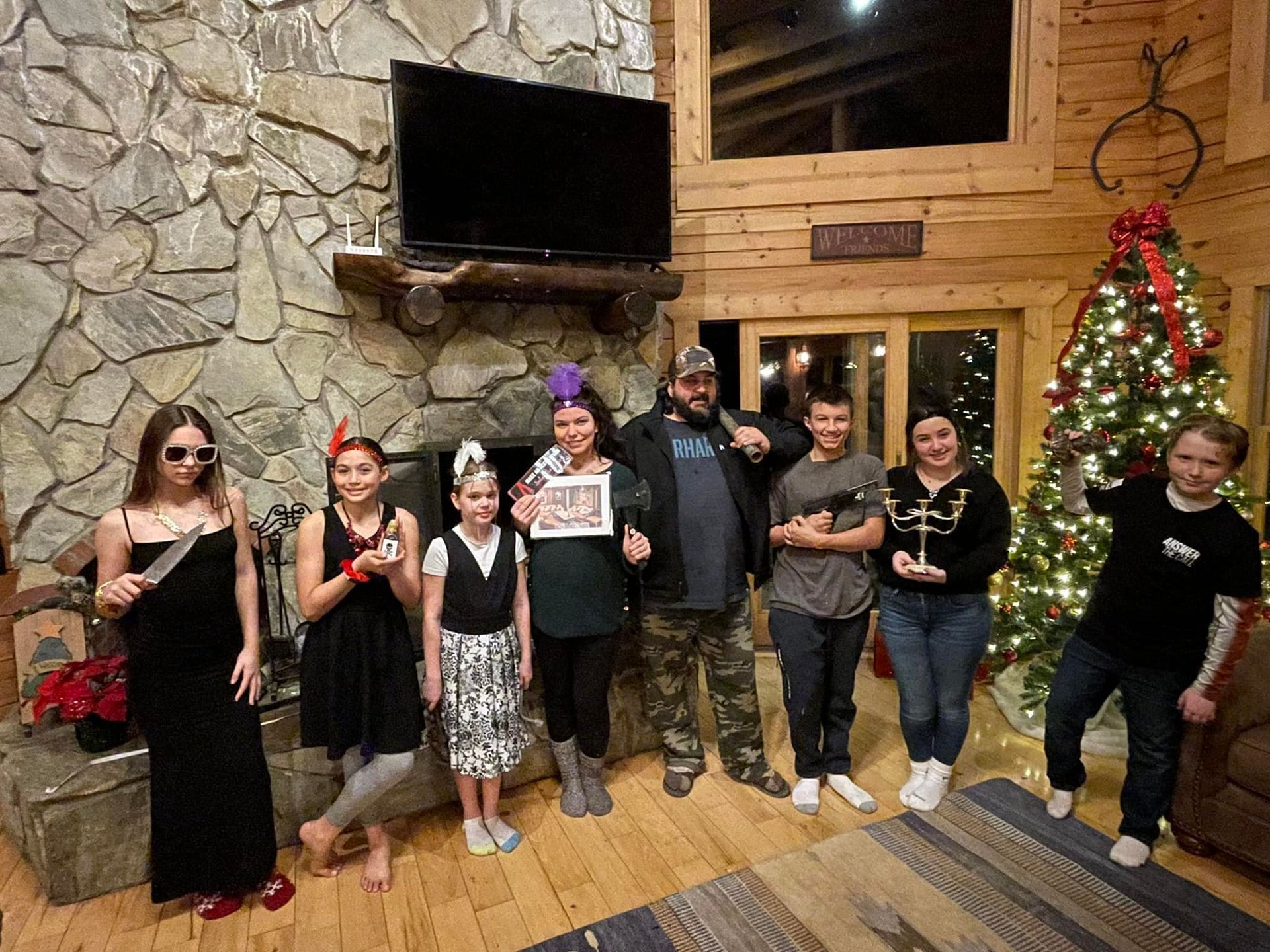 A group of people are posing for a picture in a living room in front of a christmas tree.