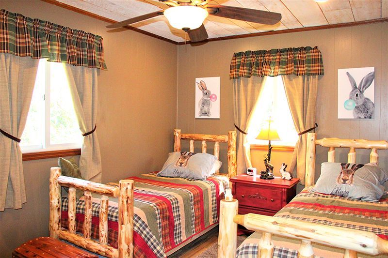 A bedroom with two beds and a ceiling fan