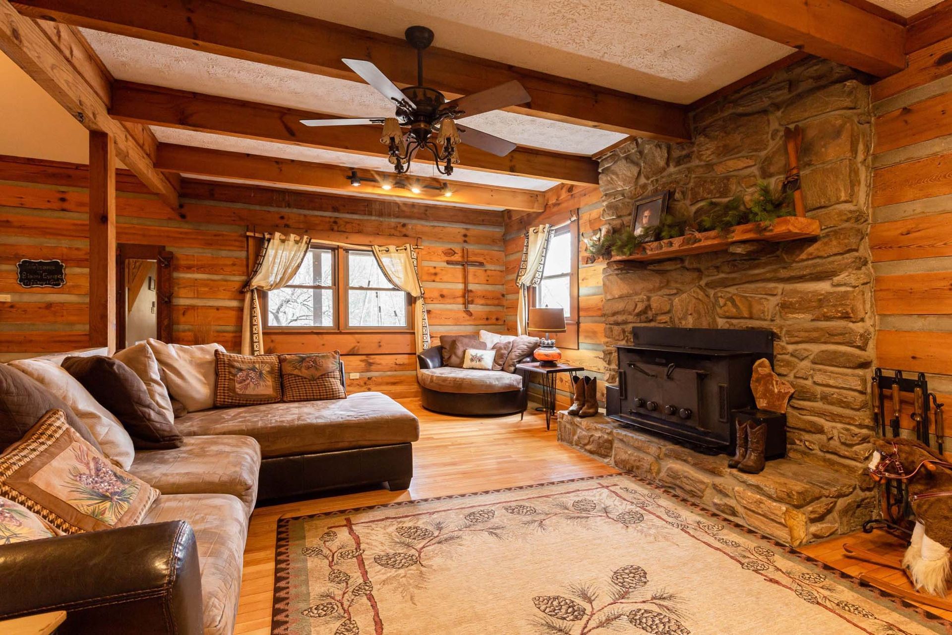 A living room in a log cabin with a fireplace and a couch.