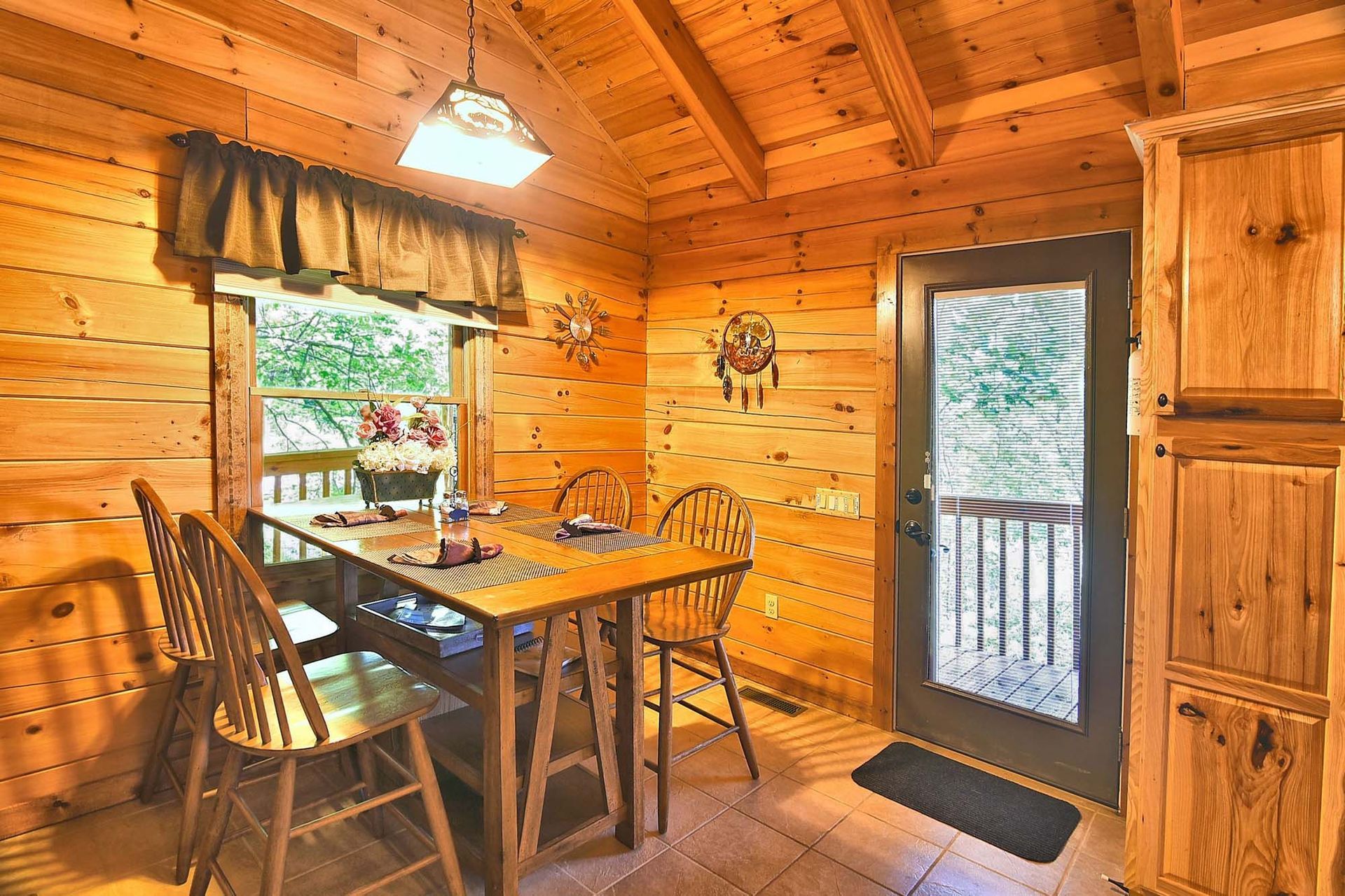 A dining room in a log cabin with a table and chairs.