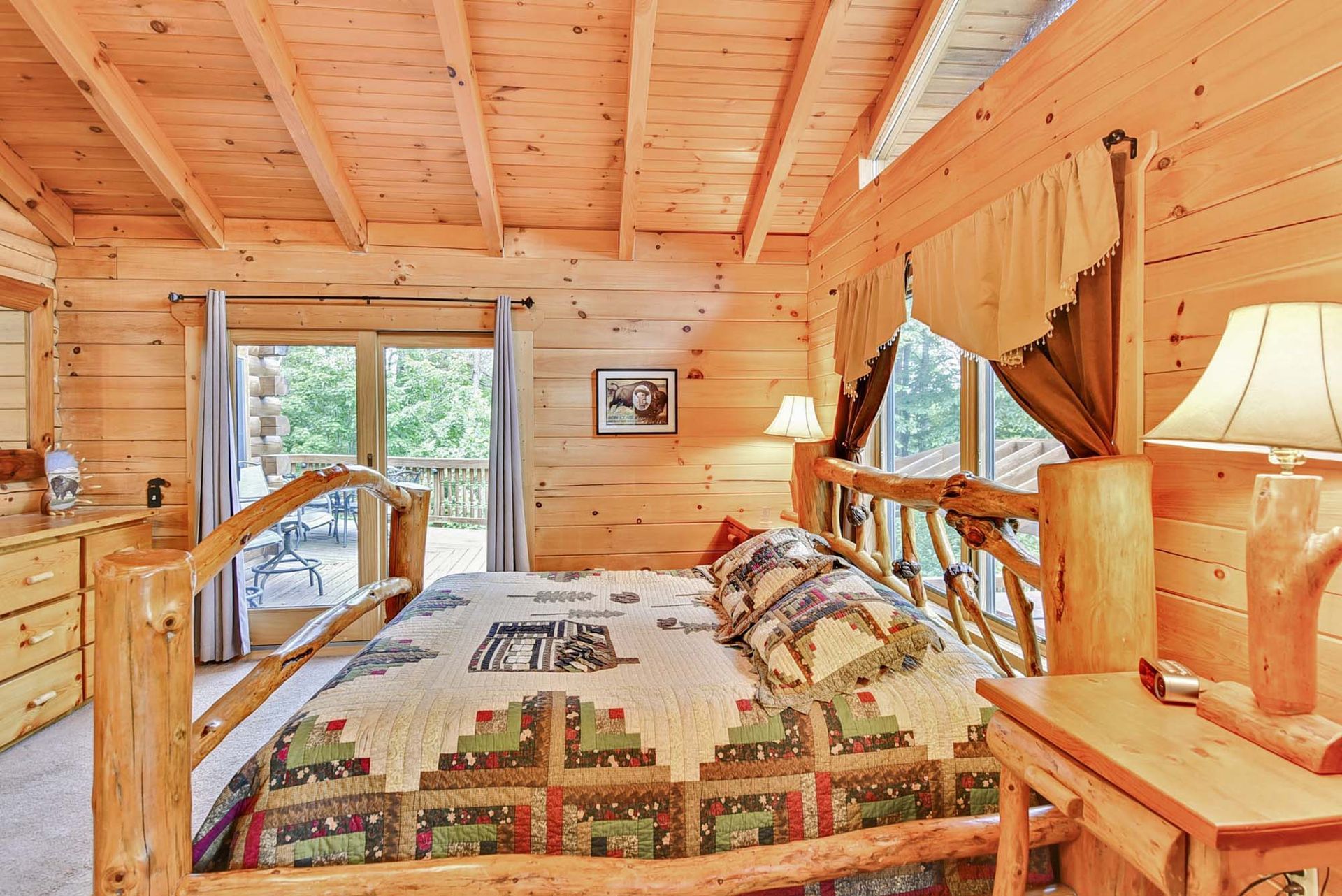A bedroom in a log cabin with a king size bed.