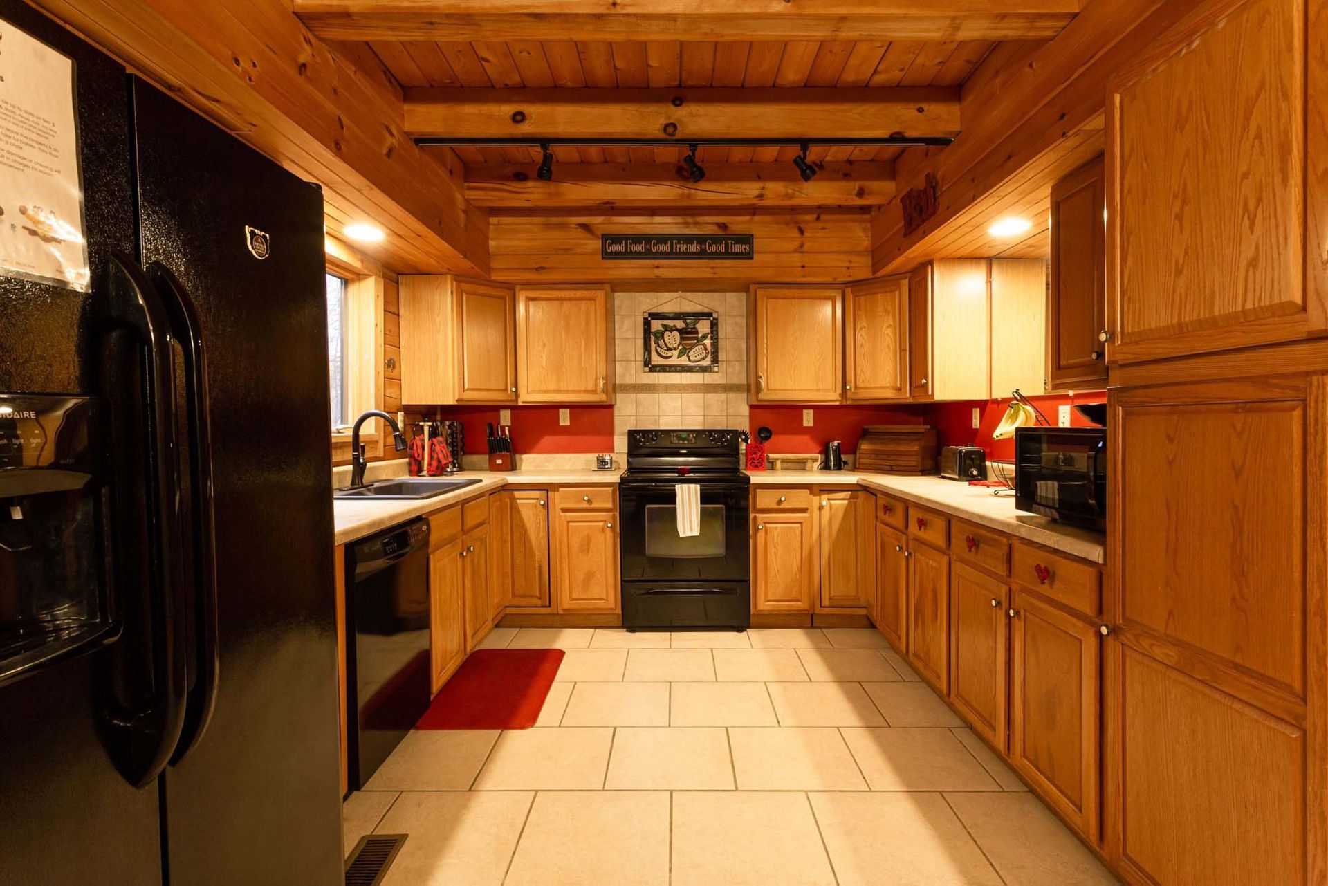 A kitchen with wooden cabinets and a black refrigerator