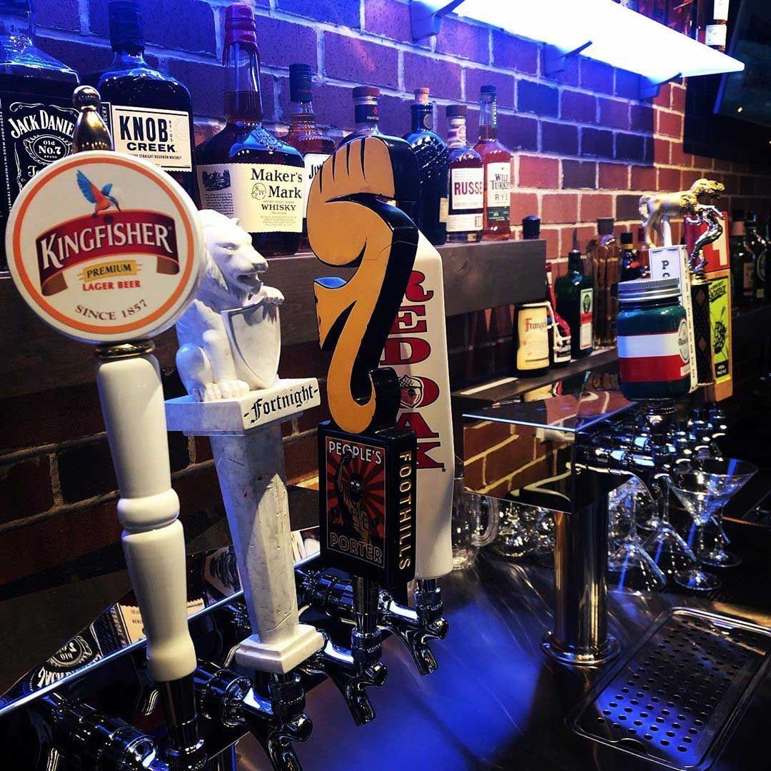 A kingfisher beer tap is on a bar